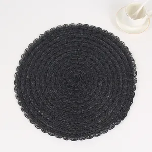 Detail of black woven placemat with concentric patterns and scalloped edges for dining decor