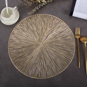 Detailed top view of a gold round hollow placemat on dark marble with coffee cup