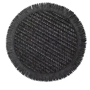 Close-up of black woven placemat with fringed edges showing rich geometric texture