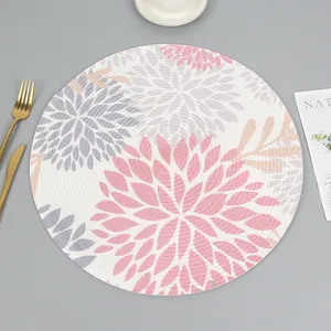 Detail of round woven placemat featuring elegant pink and purple floral patterns
