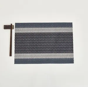 Macro detail of rectangle woven placemat featuring dark blue and silver striped textures