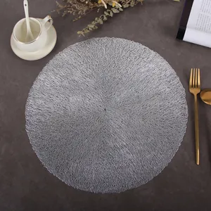 Detailed texture of silver round hollow PVC placemat with coral vein design on table