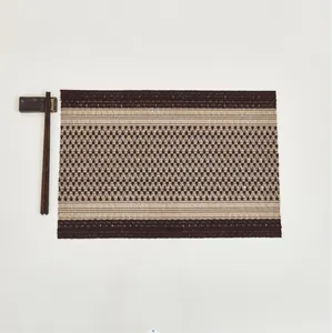 Macro detail of geometric woven table mat featuring a textured brown and beige fiber pattern