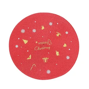 Red circular woven Christmas placemat with gold Merry Christmas embroidery and festive patterns