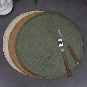 Three-piece set of round woven placemats with fringe tassels in beige, yellow and olive green
