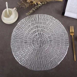 Modern silver circular hollowed-out PVC placemat with elegant radial woven texture for dining
