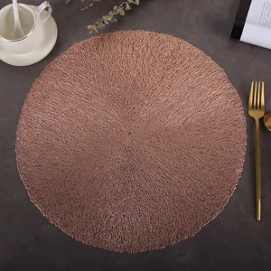 Close-up of rose gold round hollow placemat on a dark textured dining table