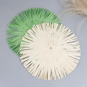 Detail of round woven paper placemats with long decorative fringe in green and beige