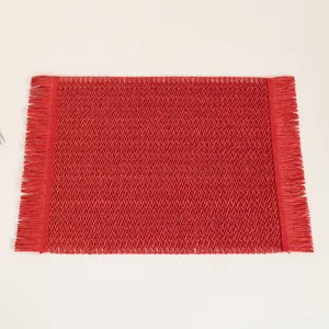Close-up of red woven placemat with elegant fringe edges and fine V-shaped texture