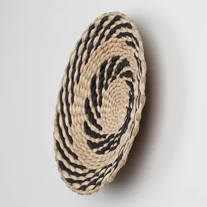 Detail view of handmade woven wall basket with natural and black spiral texture