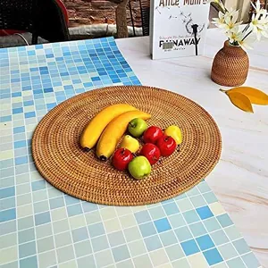 Handwoven round rattan placemat used as a fruit tray on a modern marble tabletop