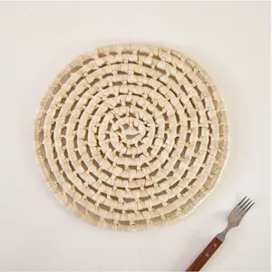 Macro detail of a handmade circular corn husk placemat with spiral woven texture