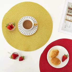 Handwoven round dining placemats in vibrant red and yellow with spiral pattern