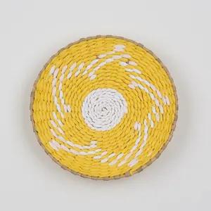 Detail of round woven wall decor featuring a yellow and white spiral pattern texture