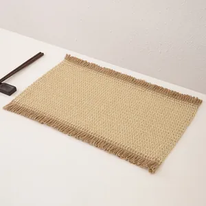 Detailed texture of woven jute placemat with fringe edges and natural two-tone design