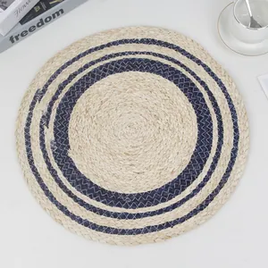 Handwoven round corn husk placemat with blue circular patterns for dining table decor