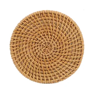 Handwoven round rattan placemat with thick spiral weave for heat insulation on white background