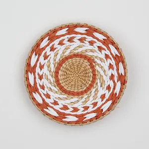 Macro shot of circular woven wall decor featuring orange and white spiral ethnic patterns