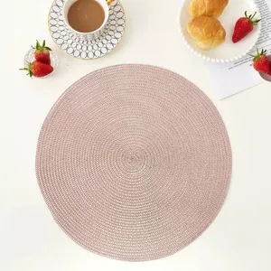 Macro detail of pink hand-woven round placemat showing spiral texture and craftsmanship
