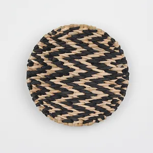 Macro shot of circular woven wall decor featuring black and natural straw fiber patterns