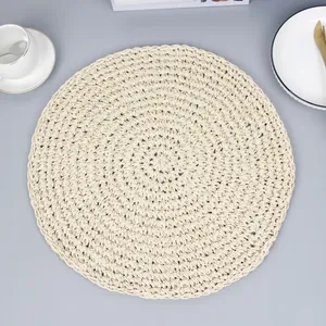 Vue verticale d'un set de table rond en papier tressé avec tasse et couverts dorés