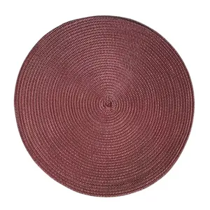 Detailed macro view of deep red woven circular placemat with spiral texture and clean edges