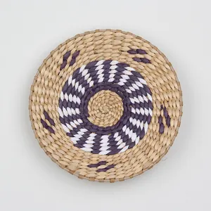 Macro detail of handwoven circular wall decor featuring purple and white spiral patterns