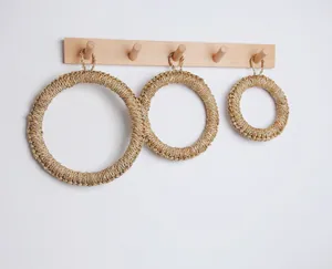 Detail von handgeflochtenen Seegras-Tischsets mit Aufhängeschlaufen am Holzregal