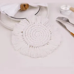 Macro detail of Nordic handwoven round cotton coaster with bohemian fringe and spiral texture