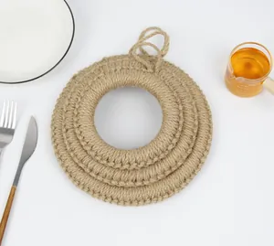 Vue détaillée de trois sets de table circulaires en jute tissés main avec boucles de suspension