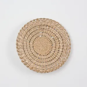 Detailed close-up of handmade woven round straw wall decor with spiral pattern