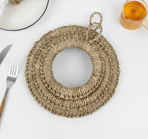 Detail von runden geflochtenen Tischsets aus Seegras mit Aufhängeschlaufe auf weißem Tisch