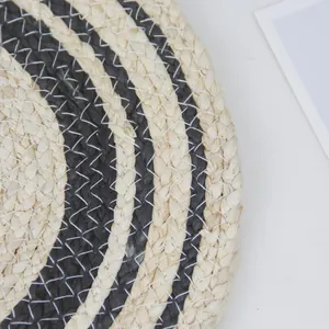 Handwoven round corn husk placemat with cream and black spiral pattern design