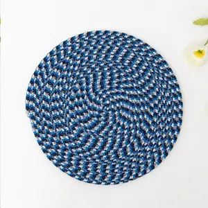 Nahaufnahme eines runden handgewebten Tischsets mit blau-weißem Spiralmuster-Detail