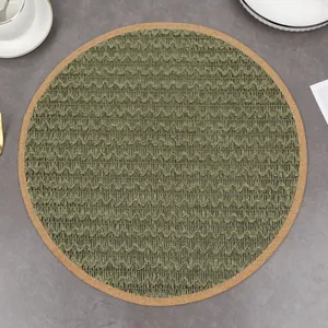 Detail of round moss green woven placemat with natural cork edge on a dinner table