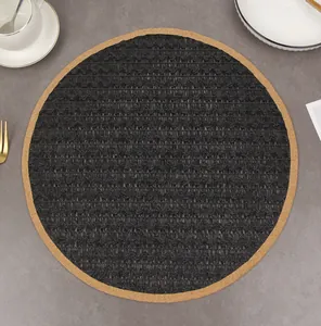 Detail of round black woven placemat with light brown border on a stone tabletop