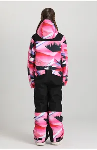 Rear view of kid's one-piece ski suit with purple mountain print and black panels