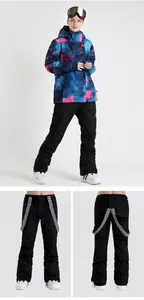 Detail of waterproof black ski bib pants with checkerboard straps and outdoor snow boots
