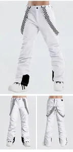 Detail of white ski bib pants with checkerboard straps and protective leg patches