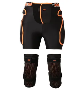 Protective padded shorts and knee pads set with orange trim for skiing and skating