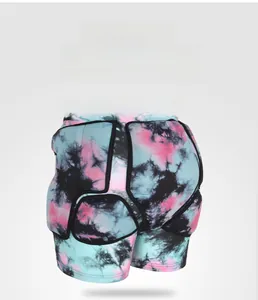 Detail view of tie-dye padded ski shorts showing thick impact protection for tailbone