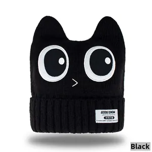 Detail of black knit beanie with cartoon large eyes and 3D cat ear design