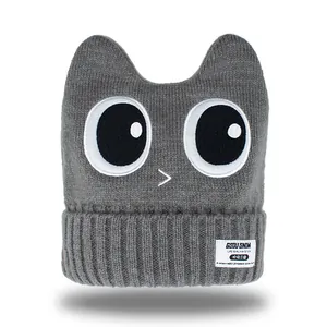 Thick grey knitted ski hat with cat ears and large cartoon eyes embroidery
