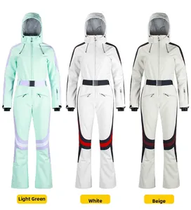 Close-up of slim-fit ski suits in mint green, white, and beige with waterproof zippers