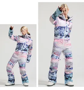 One-piece ski suit detail featuring windproof hood and mountain landscape print design