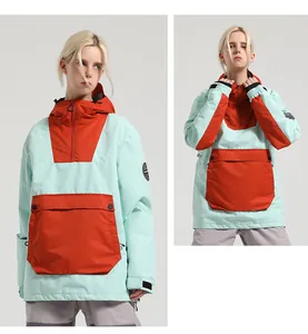 Details der Skijacke in Minzgrün und Orange mit großer Vordertasche und verstellbarer Kapuze