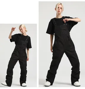 Detail of black waterproof bib ski pants with adjustable buckles and tactical pockets