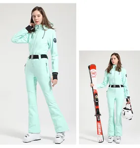 Detail of mint green slim-fit women's ski suit with adjustable black waist belt and hood