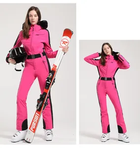 Détail d'une combinaison de ski rose fuchsia avec bordure noire et capuche en fourrure