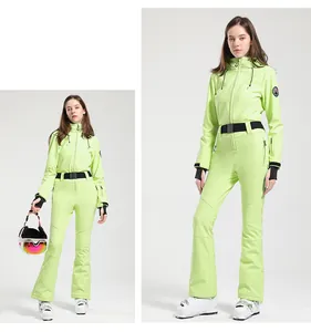 Detail of neon green women's one-piece ski suit with black waist belt and hood
